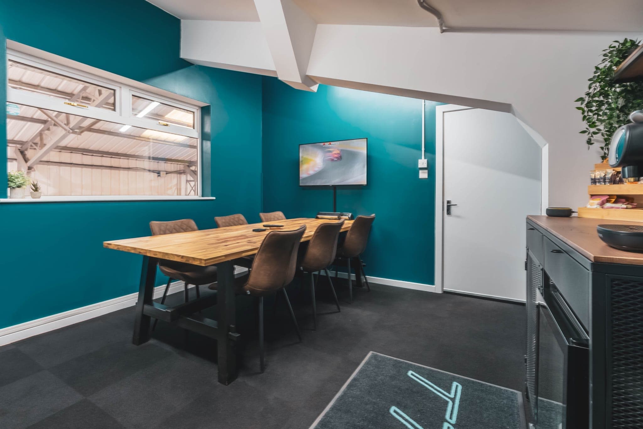 The customer suite table and chairs, with the TV and window over the workshop