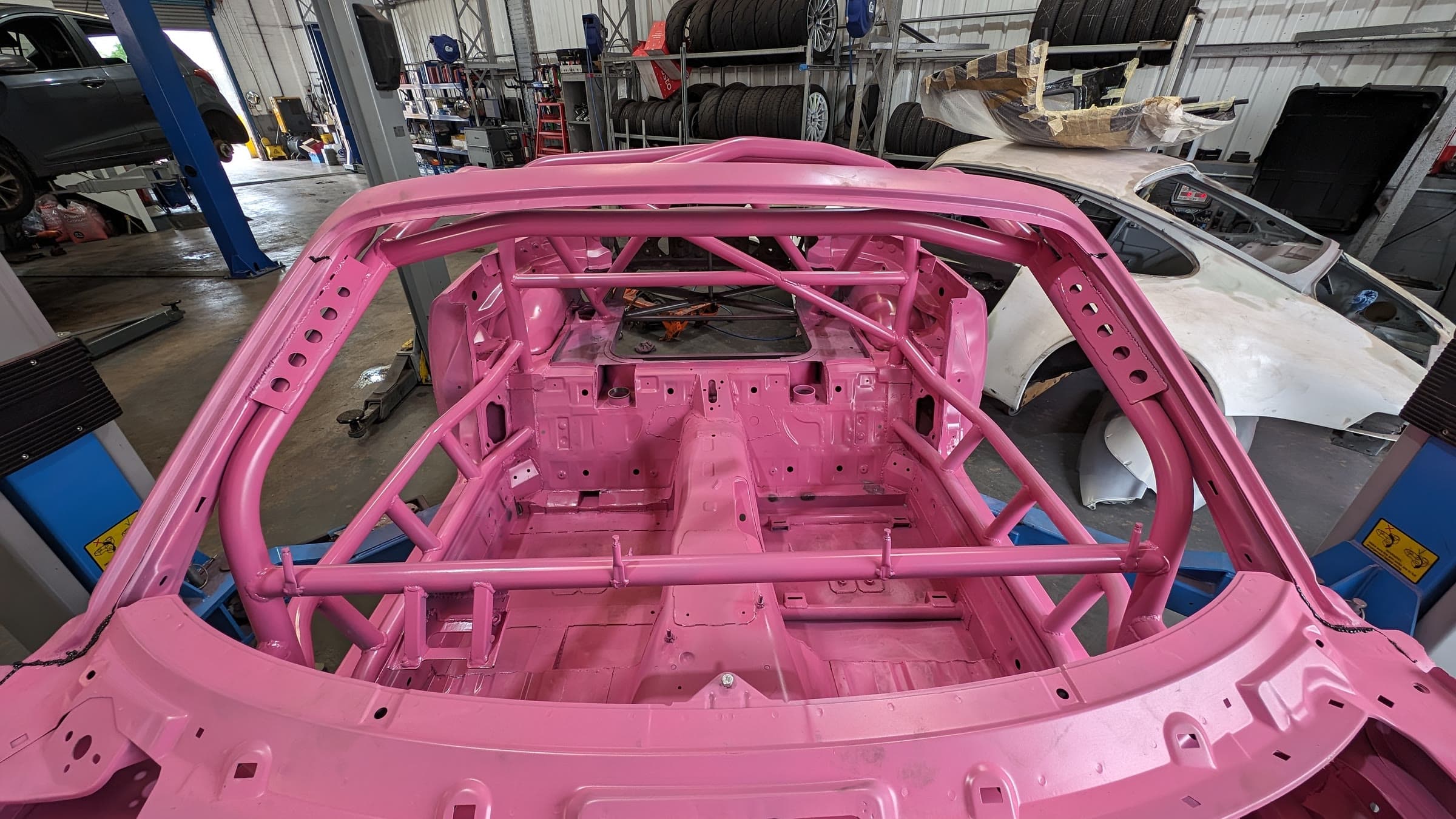 Inside the pink MX5 race shell: the full cage, painted to match