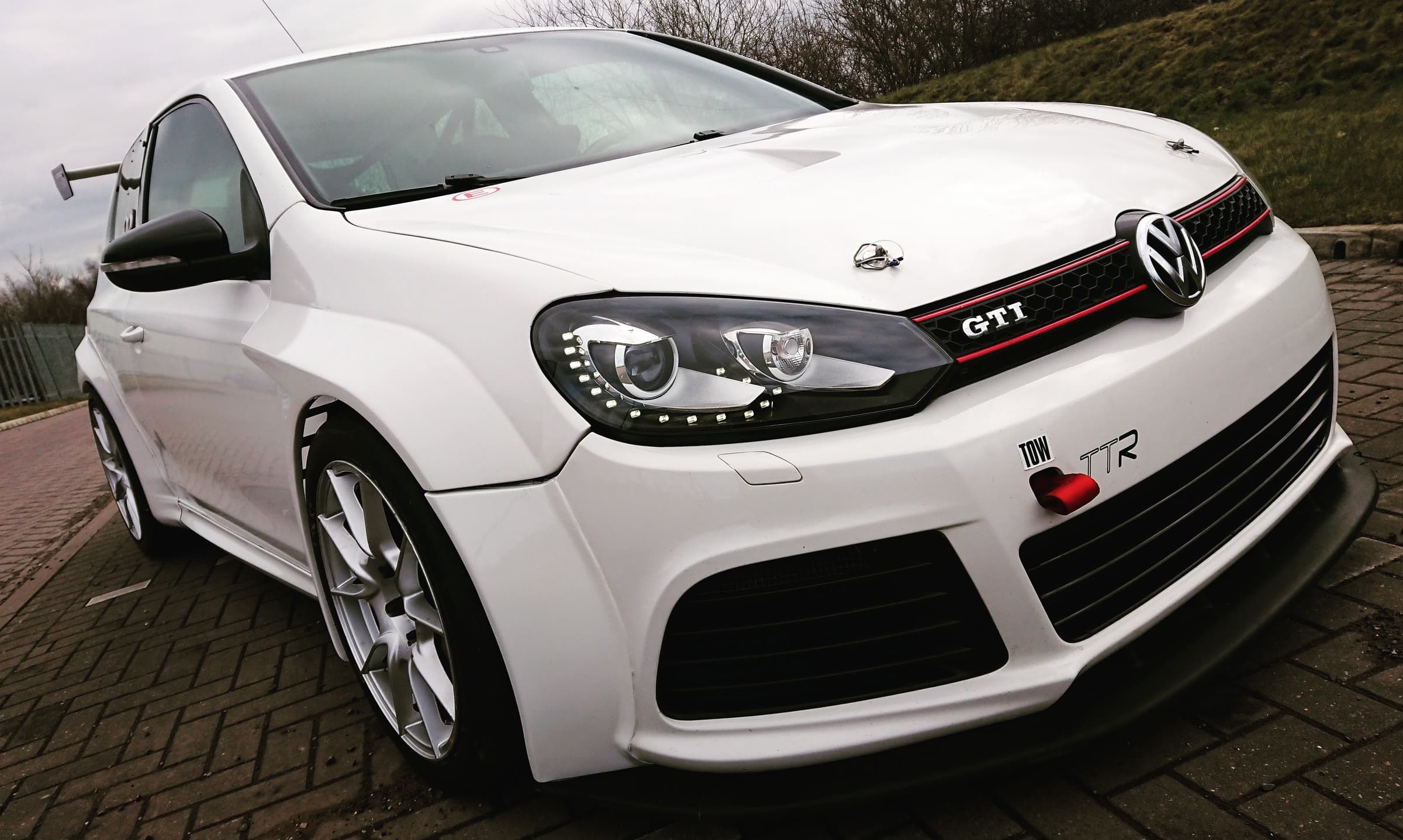 A white VW Golf GTI with a TTR badge