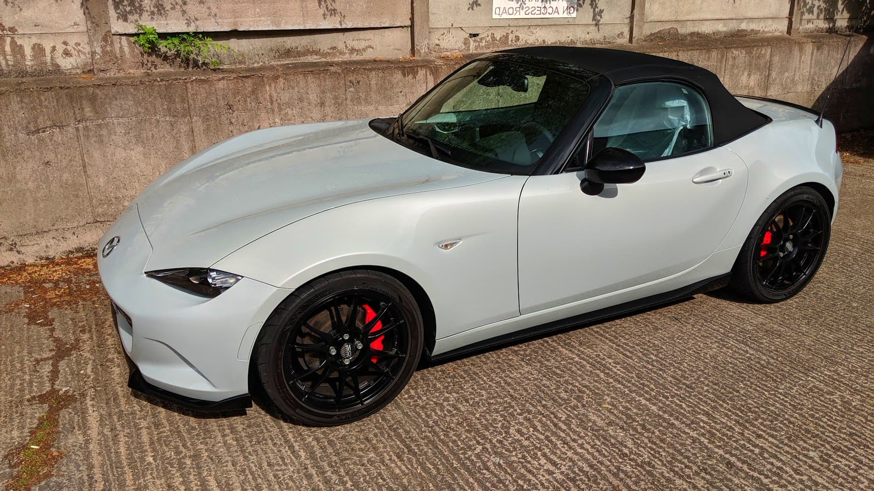 A white Mazda MX5 ND on black wheels with red calipers