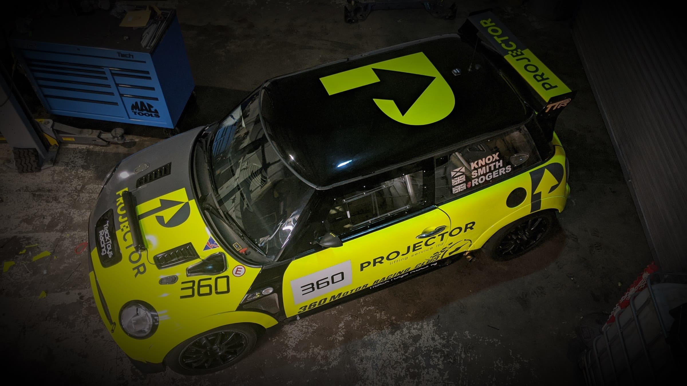 The 360 Project Mini in its yellow TrackToys Racing livery, from above, in the workshop